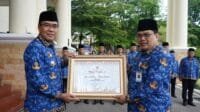 Pj Walikota Nelson Firdaus Menyerahkan Piagan, Santunan Korpri dan Tabungan Hari Tua Kepada ASN Purna Tugas